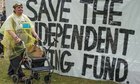 Paula Peters of DPAC walking in front of a large banner 'Save The Independent Living Fund' during the occupation of the grass outside Westminster Abbey in June 2014.