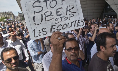 A striking taxi driver holds a placard which read, 
