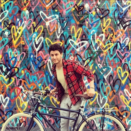 Artist James Goldcrown stands in front of his #lovewall