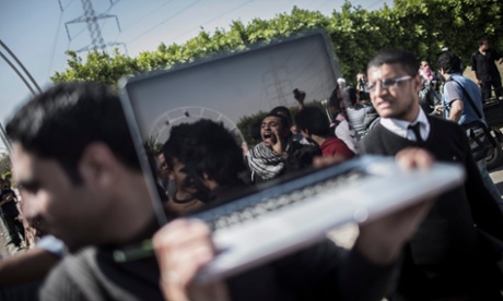 An Egyptian journalist films Islamist protesters outside Media Production City in the outskirts of Cairo, Egypt, in 2013.