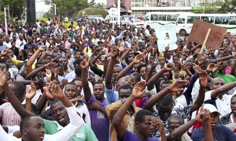 Hundreds of protesters chanting, ‘Bring back our hero’ gesture at the gate of the British high commission in Kigali, Rwanda.