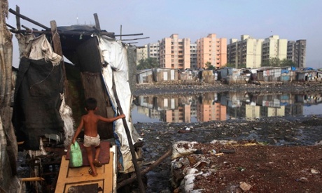 a boy walks to a latrine outside his makeshift home at a slum in Mumbai, India