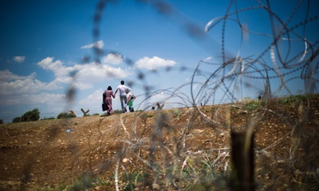 Syrian refugees crossing the Syrian-Turkish border near Marea.