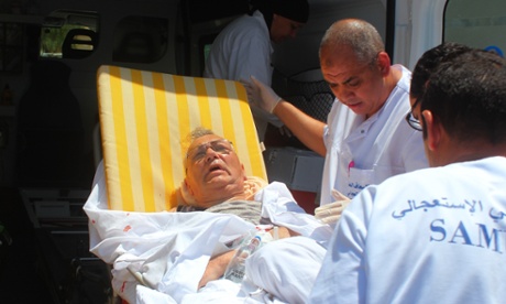 Wounded people are carried after an armed attack on a tourist hotel in Sousse, east Tunisia, left at least 27 people dead