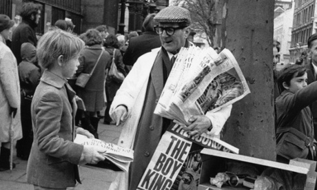 A newspaper seller on a street pitch outside the British Museum. 