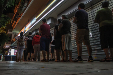 Patras, Greece. 27th June 2015 -- Greeks wait in queue to withdraw money from ATMs after Greek PM, Alexis Tsipras announcement the referendum on creditors' bailout demands.