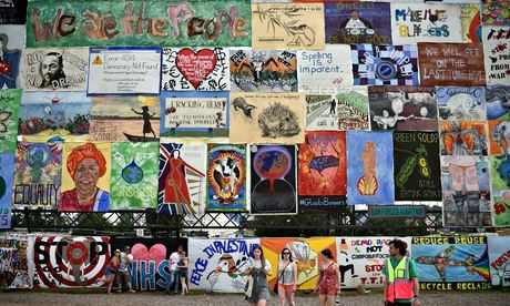 Revellers walk past an array of politica