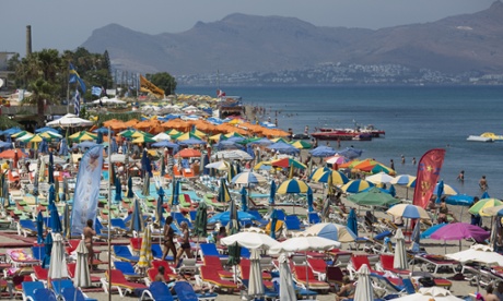 Tourists relax on the beach in Kos, Greece