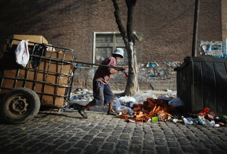  A man pulls a cart with recyclables he has collected to exchange for money near the Virgin of the Miracles of Caacupe church following Sunday Mass in the Villa 21-24 slum