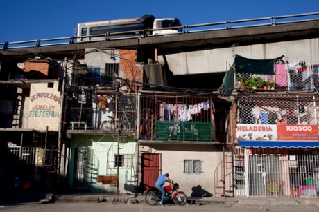 A vehicle drives on a highway over apartments in the Villa 31 neighborhood of Buenos Aires
