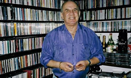Lee Stevens standing in front of his vast CD collection in his flat in London