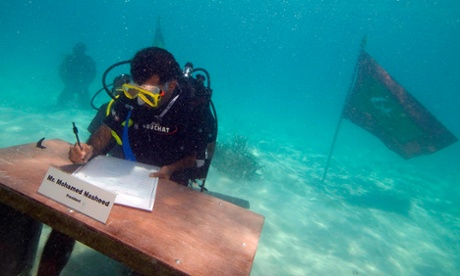 Maldives President Mohamed Nasheed signs a declaration during  the first underwater cabinet meeting in the Maldives, October 17, 2009. The Maldivian president and ministers held the world's first underwater cabinet meeting on Saturday, in a symbolic cry for help over rising sea levels that threaten the tropical archipelago's existence.