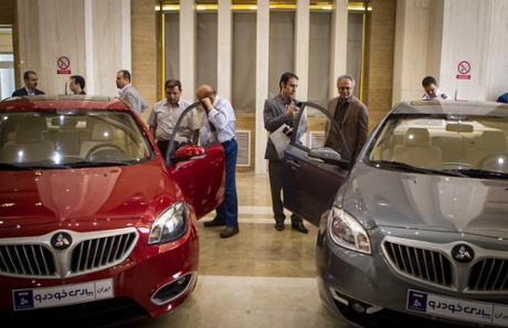 Iranian customers watch model cars of the joint assembly lines of Iran's SAIPA and China's Brilliance Auto in Tehran, Iran, on 19 May 2015. SAIPA, Iran's second largest carmaker, launched two assembly lines last month in cooperation with China's Brilliance Auto.