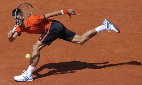 Novak Djokovic returns at full stretch to Rafael Nadal.