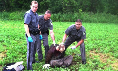 Police stand over David Sweat after he was shot and captured near the Canadian border in Constable, N.Y.
