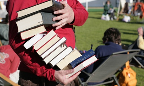 A man at the Hay festival with a pile of books.