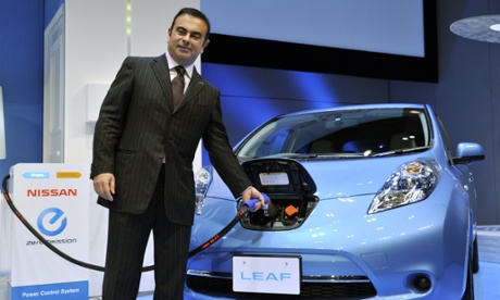 Japan's auto Nissan president Carlos Ghosn charges the electric vehicle 'Leaf' during an announcement of the the company's new mid-term environment plan
