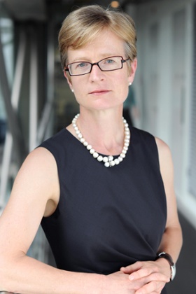 Laura Wade-Gery in sleeveless black dress and pearl necklace