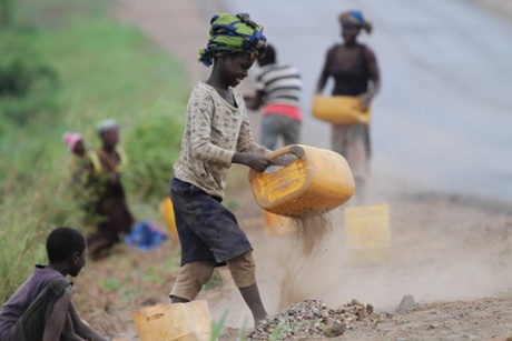 A girl sifts roadside sand to separate the stones to sell as building material in Inchope, northern Mozambique.