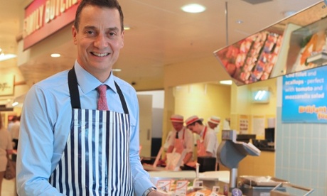 Dalton Philips, chief executive of Morrisons, in   apron and holding a plate of fish at the deli counter