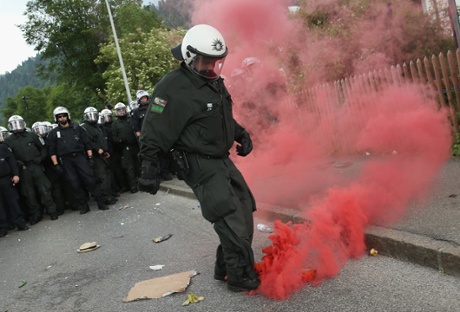 A policeman kicks away a smoke bomb during scuffles during a march by anti-G7 protesters through Garmisch-Partenkirchen.