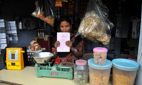 A woman poses with her microfinance ‘loan recovery book’ at her shop in Hyderabad, India