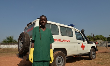 Masray Kamara beside the ambulance used to transport the dead bodies of Ebola victims.