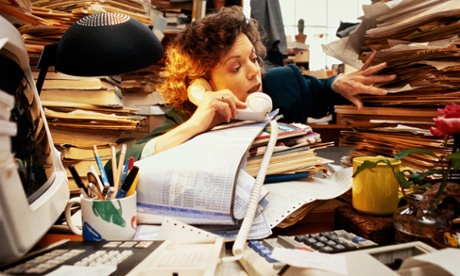 stressed worker with lots of files on desk