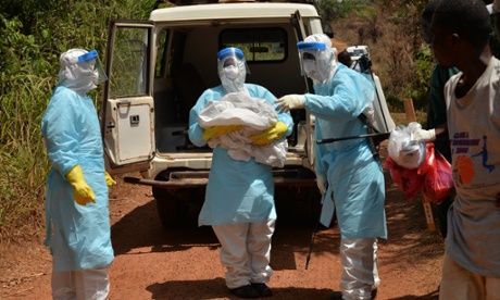 Maseray Kamara carries a body from the ambulance to the burial space.