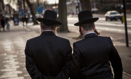 Jewish men walk along the street in the Stamford Hill area 