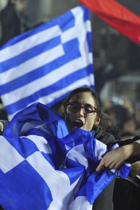 A woman waves a Greek flag.