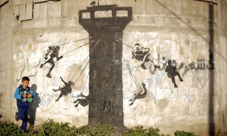 A Palestinian child walks past a mural in the Gaza Strip town of Beit Hanun.