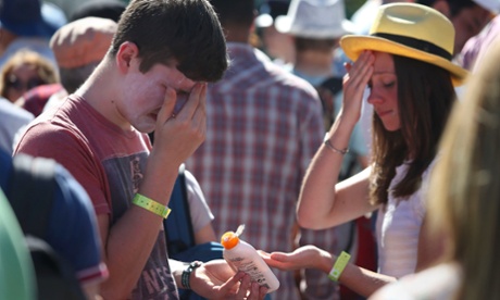 Spectators put on suncream, during day two of the Wimbledon Championships.