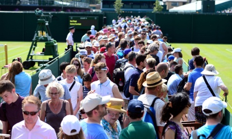 Spectators squeeze between courts four and five during day Three of the Wimbledon Championships.