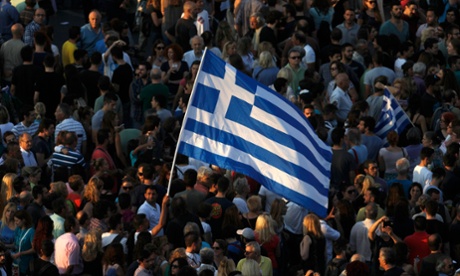 Protesters wave a Greek flag