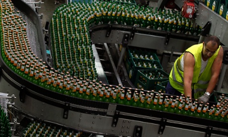 A worker adjusts bottles filled with Zlatopramen radler beer 