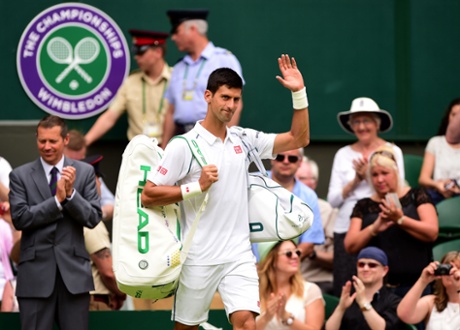 Novak Djokovic waves to the crowd as he enters Centre Court.