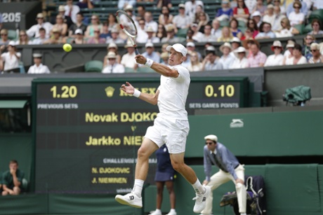 Jarkko Nieminen fires the ball to Novak Djokovic.