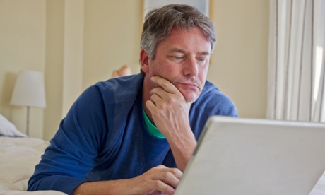 Senior using laptop in bed.