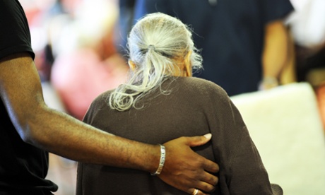 An elderly Sikh lady is helped to her chair in a multicultural extra Care home Bradford West Yorkshire.