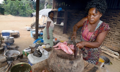 A woman cuts rabbit meat at a 