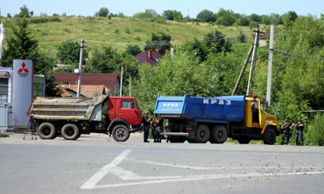 Ukrainian servicemen guard entrance to the western city of Mukacheve, after fighting between police and Right Sector fighters took place on Saturday.