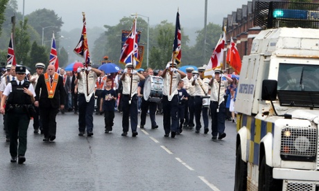 A file picture taken on July 12, 2014, shows police escorting an Orange Order parade past the nationalist Ardoyne area of North Belfast. 