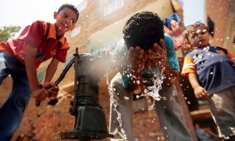 Children drink water and wash from a hand pump in Qalyoubia village north of Cairo.