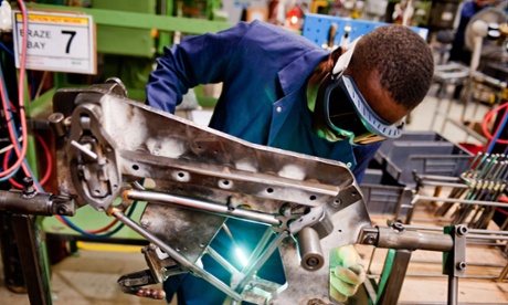 A workman brazes components of a  folding bike in the Brompton Bicycle factory