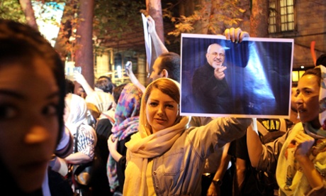 A woman holds a poster of the Iranian foreign minister as people in Tehran celebrate the nuclear deal.