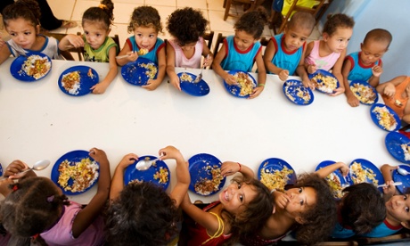 Brazilian children gaze up during lunch. Based on the Brazil model, school feeding programme have been launched throughout Latin America and the Caribbean. <br>