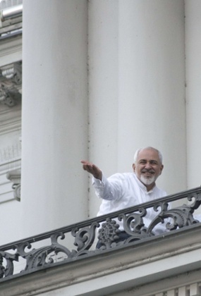Iranian foreign minister Mohammad Javad Zarif gestures towards reporters from a balcony of the Palais Coburg Hotel.