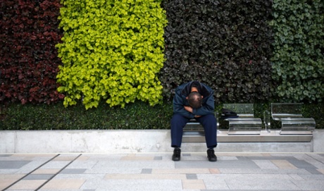 A man takes a nap on a bench in Tokyo.