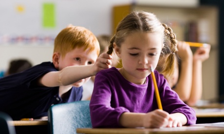 Young boy leaning forward and pulling girl's hair.